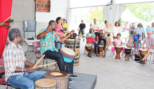 Amadou Kienou, with arms raised,  teaching West African drumming at Harbourfront Centre last summer. Copyright ©2014 Ruth Lor Malloy